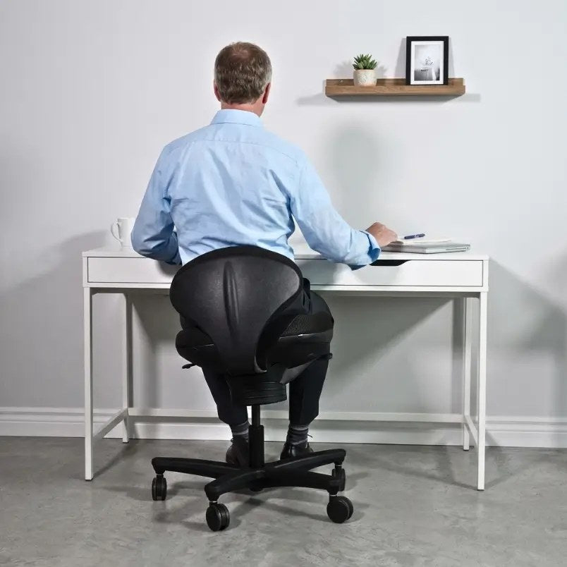 Man at a modern office desk on a black CoreChair Classic