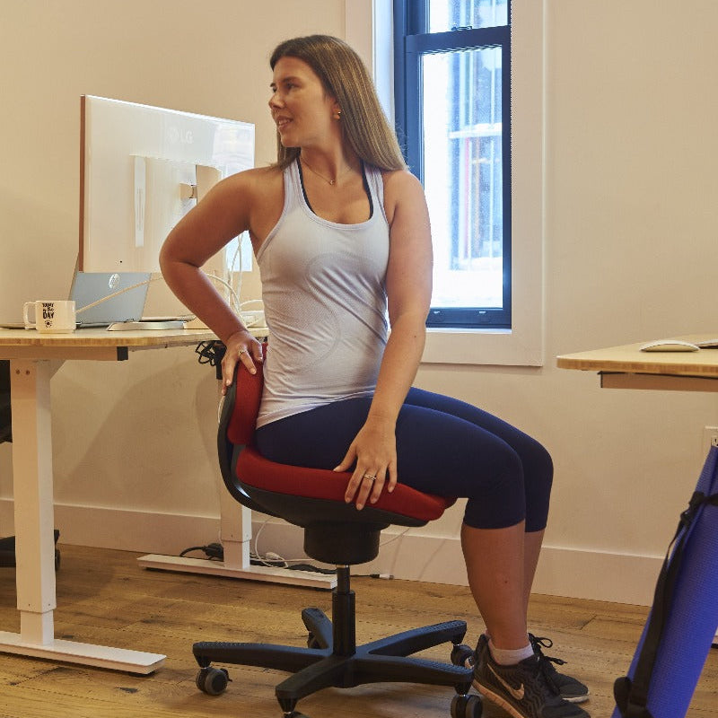 CoreChair Tango in red. Using the Tango to stretch while at work from Active Goods Canada