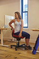 CoreChair Tango in red. Using the Tango to stretch while at work from Active Goods Canada