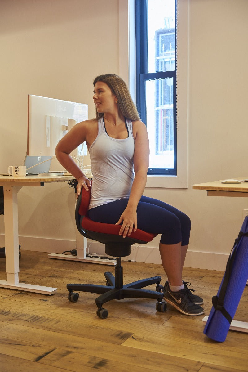 CoreChair Tango in red. Using the Tango to stretch while at work from Active Goods Canada