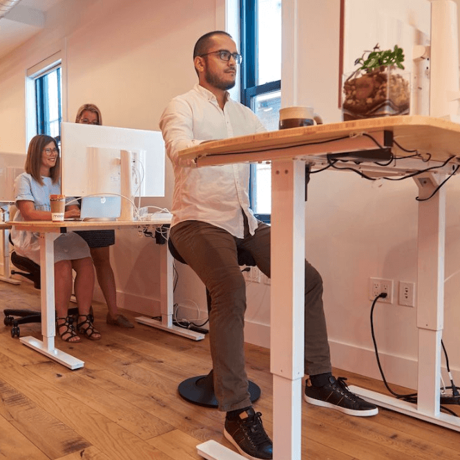 CorePerch Active Stool perching at standing office desk by Active Goods Canada