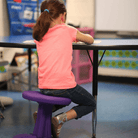 Girl using Kore Kids Wobble Chair 14" in classroom from Active Goods Canada