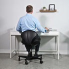 Man at a modern office desk on a black CoreChair Classic