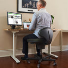 Man working at a standing desk on a Speckled Black CoreChair Classic