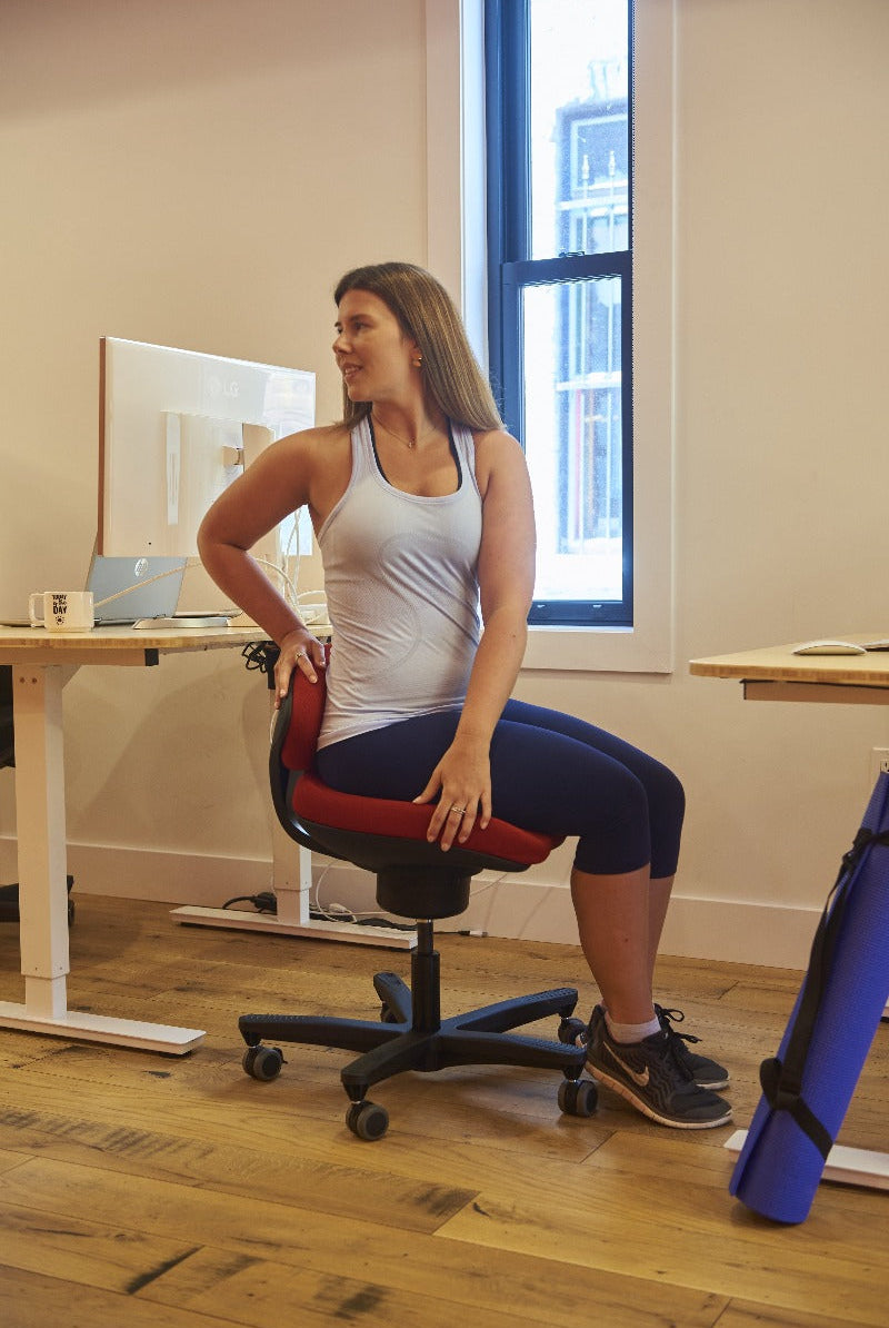 CoreChair Tango in red. Using the Tango to stretch while at work from Active Goods Canada
