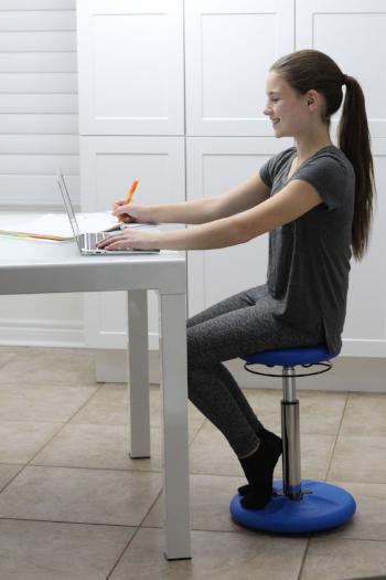 Girl using Kore Kids Height-Adjustable Wobble Chair at desk from Active Goods Canada
